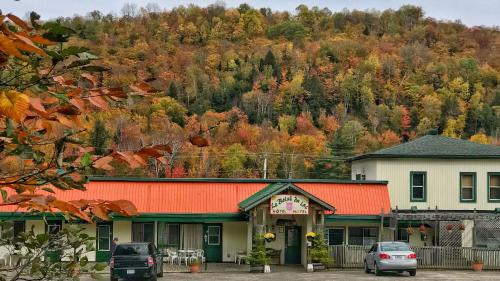 a building with an orange roof in front of a mountain at Le Boisé du Lac in Mont-Tremblant