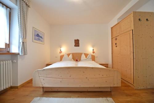 a bedroom with a large wooden bed in a room at Apartments Dolomie in Ortisei