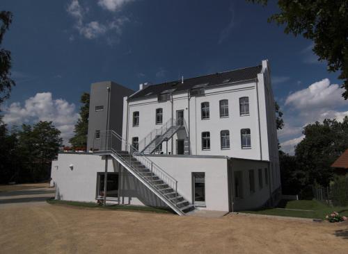 a white building with a staircase on the side of it at Hotel zwischen den Seen in Waren