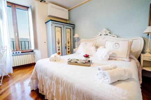 una camera da letto con un letto bianco con asciugamani e fiori di Ripa Medici, camere con vista e parcheggio incluso a Orvieto