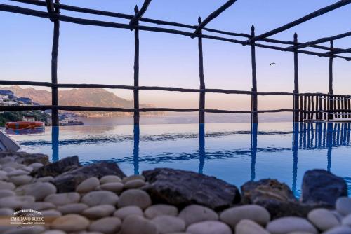 una piscina de agua con rocas y un cuerpo de agua en Villa Alba d'Oro, en Amalfi