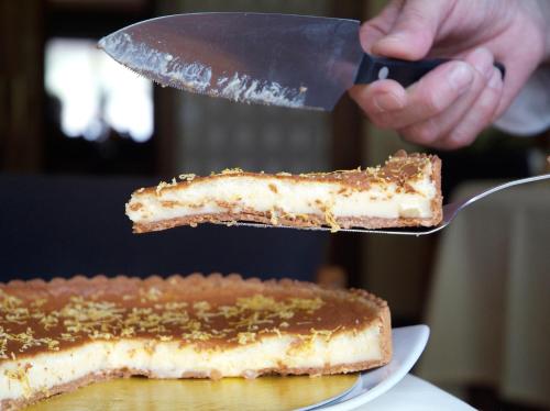 a person cutting a piece of cake with a knife at Hotel Emporda in Figueres