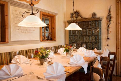 ein Esszimmer mit einem langen Tisch mit weißem Tischtuch in der Unterkunft Landgasthof Rössle - Beim Kräuterwirt in Oberstaufen