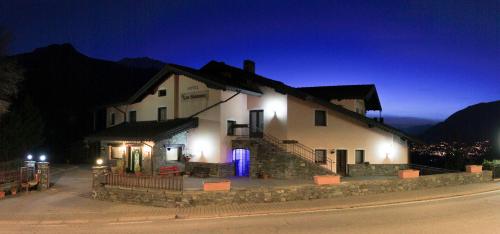 a large white building with lights on it at night at Hotel Les Saisons in Saint Vincent