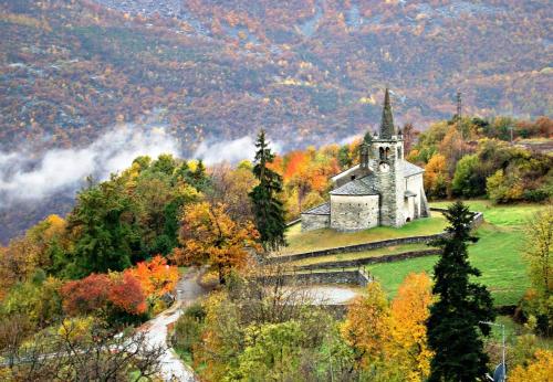 an old church on a hill in the mountains at Hotel Les Saisons in Saint Vincent