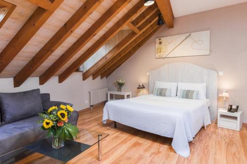 um quarto com uma cama branca e um sofá em Auberge Communale de Carouge em Genebra