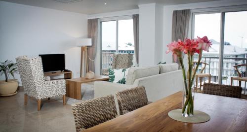 uma sala de estar com um vaso de flores sobre uma mesa em The Quadrant Luxury Apartments em Victoria