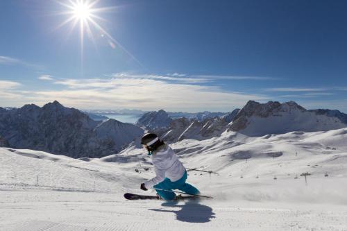 une personne est en train de skier sur une montagne enneigée dans l'établissement Gästehaus Marianne, à Grainau