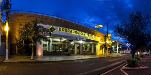 un bâtiment au coin d'une rue la nuit dans l'établissement Dourados Center Hotel, à Dourados