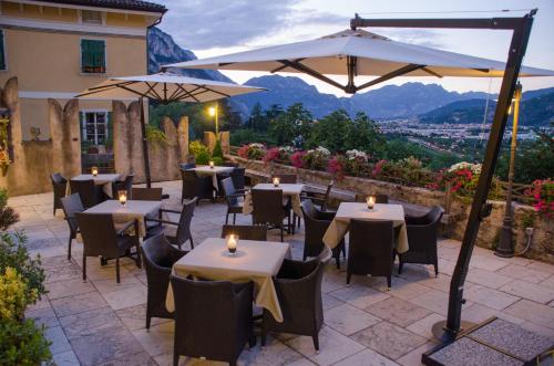 een restaurant met tafels en stoelen en een parasol bij Garnì San Giorgio Della Scala Rooms and Breakfast in Trento