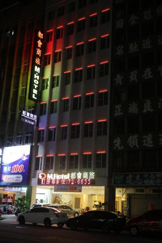 een hoog gebouw met rode lichten aan de zijkant bij M Hotel in Kaohsiung