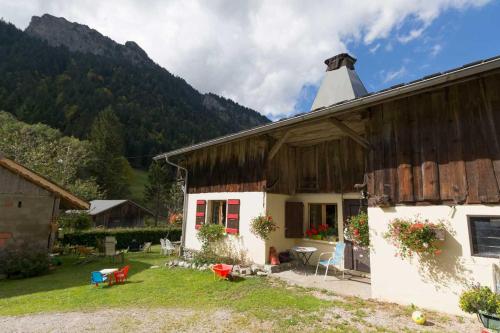 een wit huis met een schuur met bergen op de achtergrond bij Les Allamands in Morzine