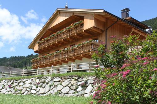 een gebouw met een balkon met bloemen erop bij Huberhof in San Candido