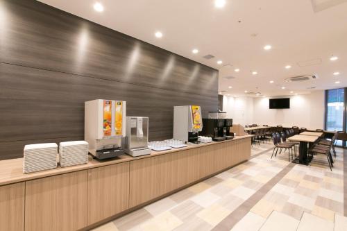 a fast food restaurant with a counter and tables and chairs at R&B Hotel Shin Osaka Kitaguchi in Osaka