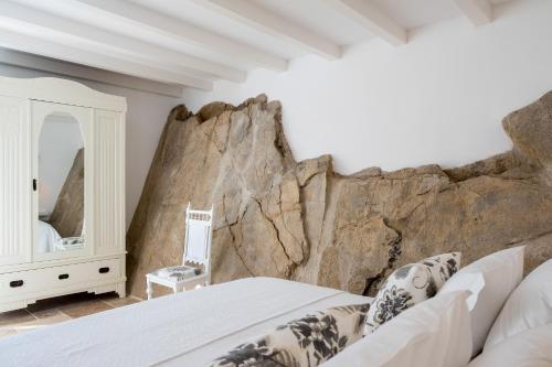 - une chambre avec un grand mur en pierre dans l'établissement Lugares Com História, à Óbidos