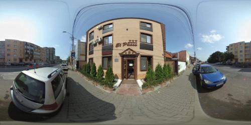 a reflection of a building with cars parked in front of it at Pensiunea El Passo Targu Mures in Târgu-Mureş