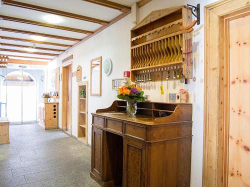 a kitchen with a wooden counter with a vase of flowers at Hotel Alpina in Zernez