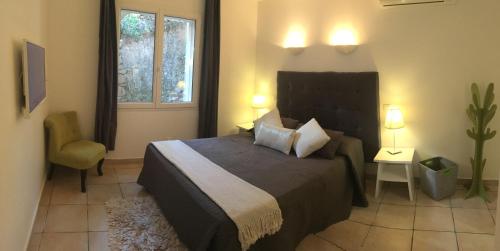 een slaapkamer met een bed, een stoel en een raam bij Residence Bellavista à Santa Giulia, proche de la plage et vue mer in Porto-Vecchio