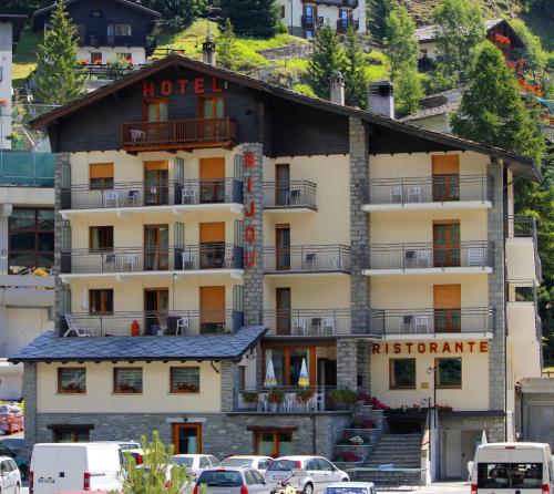 een hotel op een berg met auto's voor de deur bij Hotel Bijou in Valtournenche