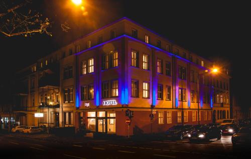 un bâtiment avec une lumière bleue la nuit dans l'établissement Hotel Alexander, à Wiesbaden