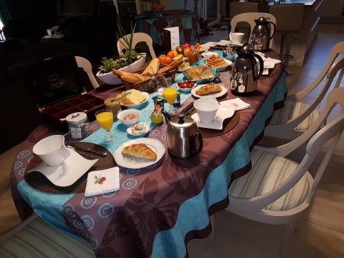 uma mesa longa com comida e bebidas em Chambres d'Hôtes La Villa des Hortensias em Berck-sur-Mer