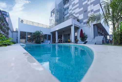 a swimming pool in front of a building at The Palms by Eagles Accra in Accra