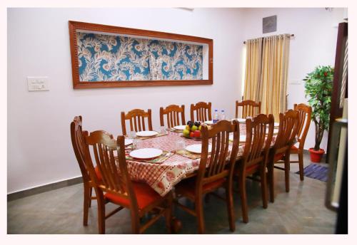 提喀迪Periyar Villa Home Stay - Thekkady的一间带桌椅的用餐室