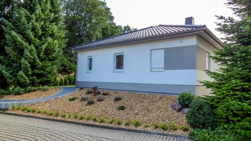 uma pequena casa branca com uma entrada em Ferienhaus im Erzgebirge em Chemnitz