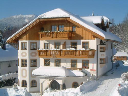 a house with a balcony in the snow at Hotel Brunnenhof in Bayerisch Eisenstein