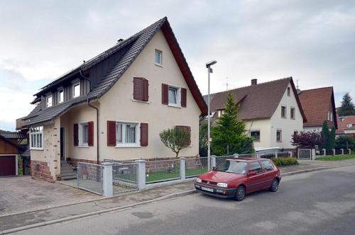 un coche rojo estacionado frente a una casa en Apartment Moritz, en Lahr