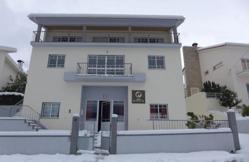 - un bâtiment blanc avec un balcon dans la neige dans l'établissement Casa Mariolas, à Manteigas