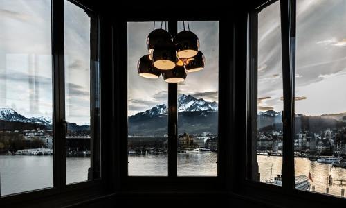 d'une fenêtre avec un lustre et une vue sur les montagnes. dans l'établissement Lucerne Lake View Apartments, à Lucerne