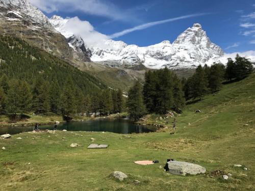 un lago en un campo con una montaña en el fondo en CERVINIA - Appartamento direttamente sulle piste, vista unica sul Cervino, en Breuil-Cervinia