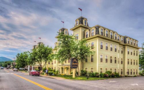 ein großes gelbes Gebäude an der Straßenseite in der Unterkunft Bar Harbor Grand Hotel in Bar Harbor