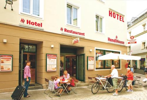 a group of people sitting at a table outside a hotel at StadtHotel Passau in Passau