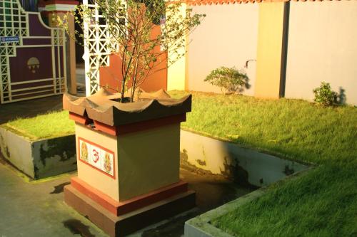 a potted tree in a planter in a yard at ShivalayaHomestay in Trichūr