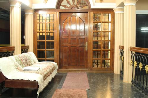 a living room with a wooden door and a couch at ShivalayaHomestay in Trichūr