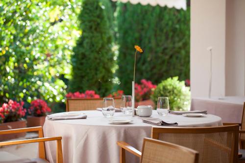 a table with wine glasses and a flower on it at Hotel Emporda in Figueres