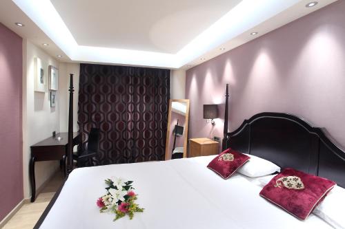 - une chambre avec un grand lit fleuri dans l'établissement Comfy Boutique Hotel, à Kalamata