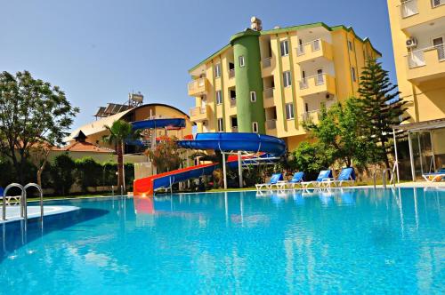 une grande piscine avec toboggan en face de certains bâtiments dans l'établissement Melissa Garden Apart Hotel, à Sidé