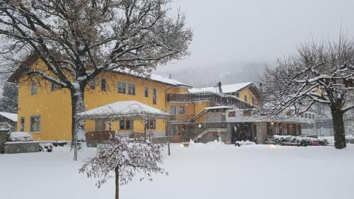 un cortile coperto da neve con un edificio giallo di Hotel Castello a Montjovet