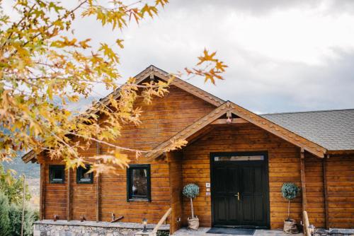 een blokhut met een zwarte deur bij Pasithea Mountain Chalet in Feneos