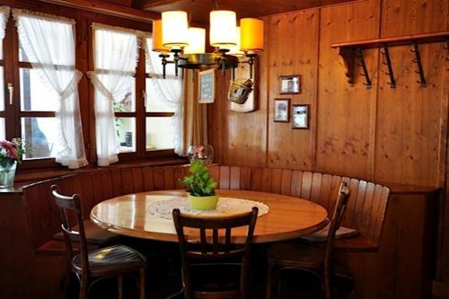 a dining room with a wooden table and chairs at Gasthaus Skiklub in Andermatt