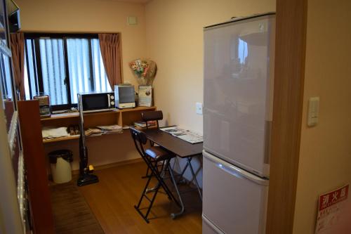 una cucina con frigorifero e una scrivania con computer di Daiya Ryokan a Kyoto