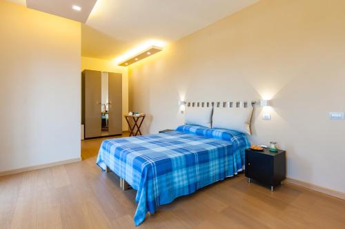 a bedroom with a bed with a blue plaid blanket at Villa Viuli in Torre del Greco