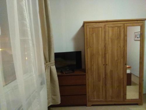 ein Schlafzimmer mit einem Holzschrank und einem Fenster in der Unterkunft Hotel Lidový dům in Nový Hrozenkov