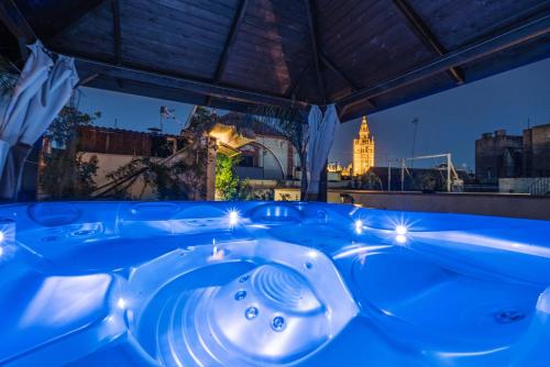 een jacuzzi 's nachts met uitzicht op de stad bij El Rey Moro Hotel Boutique in Sevilla