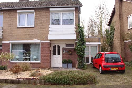 une voiture rouge garée devant une maison dans l'établissement Tanja's B&B, à Maastricht