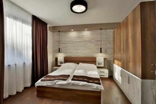 a bedroom with a bed and a brick wall at Apartments Relax 1&2 in Varna City