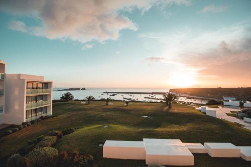 vista su un edificio e sull'oceano al tramonto di Memmo Baleeira - Design Hotels a Sagres